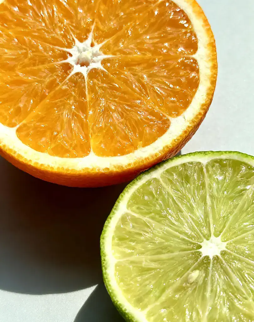 Juicy orange and lime slices, fresh citrus fruits, vibrant summer fruit, healthy snacks, citrus flavor, refreshing fruit visuals, MISTURA BODYMIST ingredients.